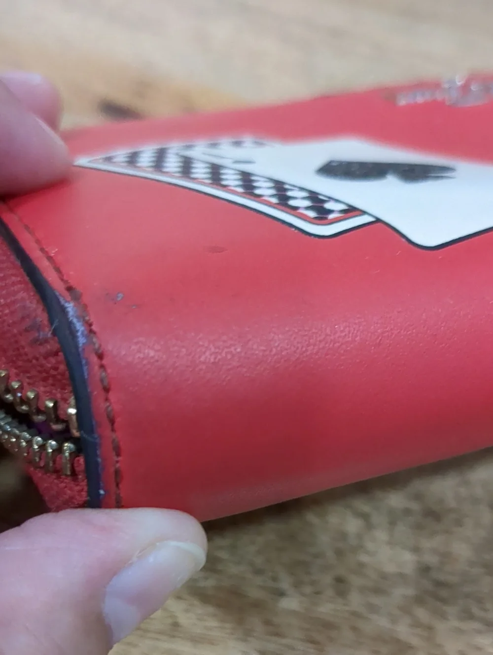 Kate Spade red zip-around wallet with Ace of Spades patch